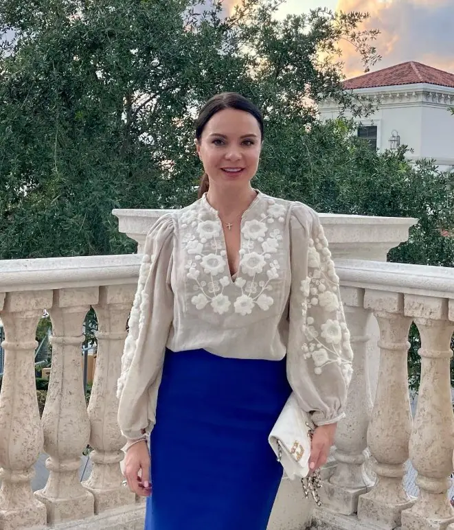 Woman in a light vyshyvanka with voluminous sleeves and a blue pencil skirt